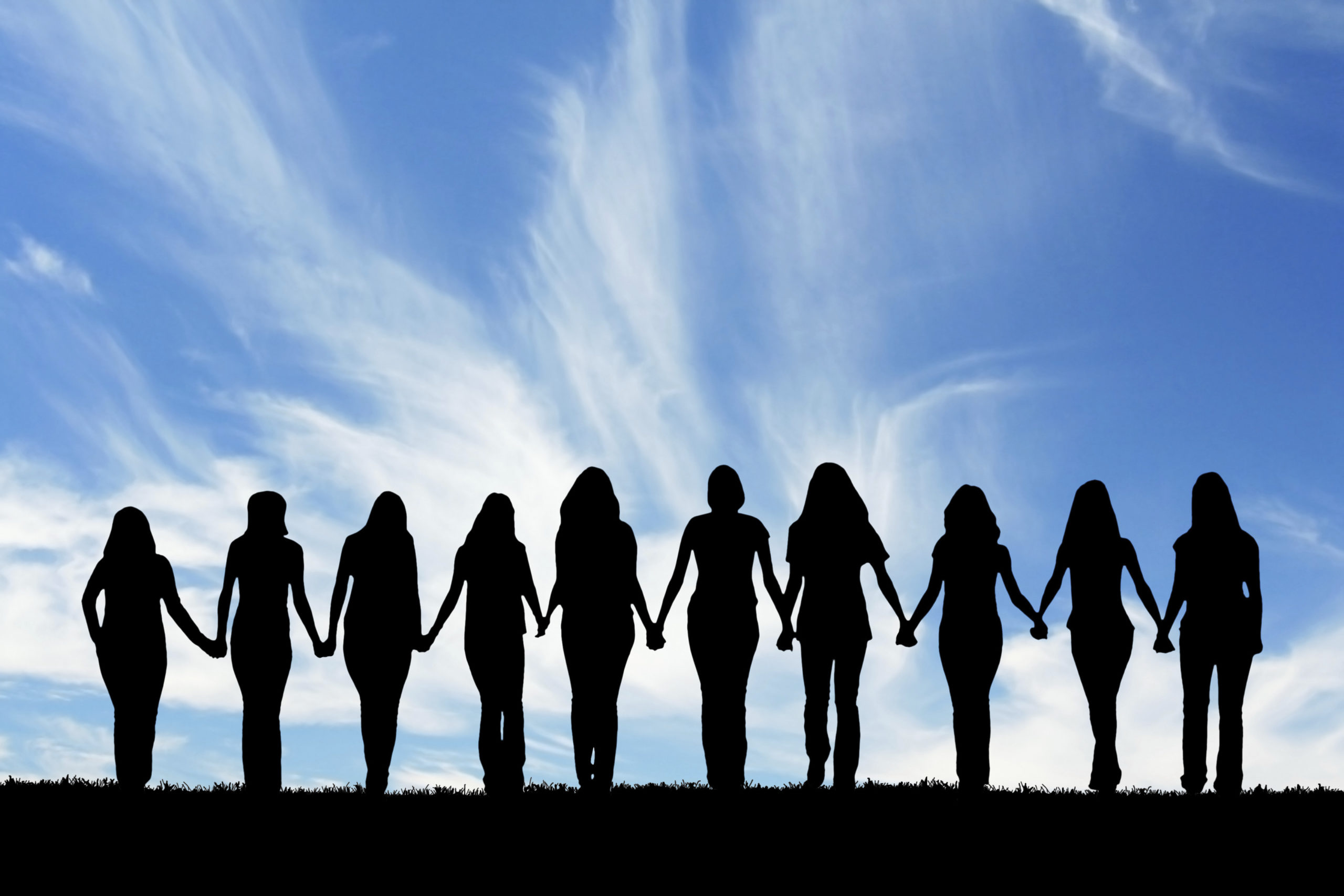 Silhouette of ten young women, walking hand in hand.