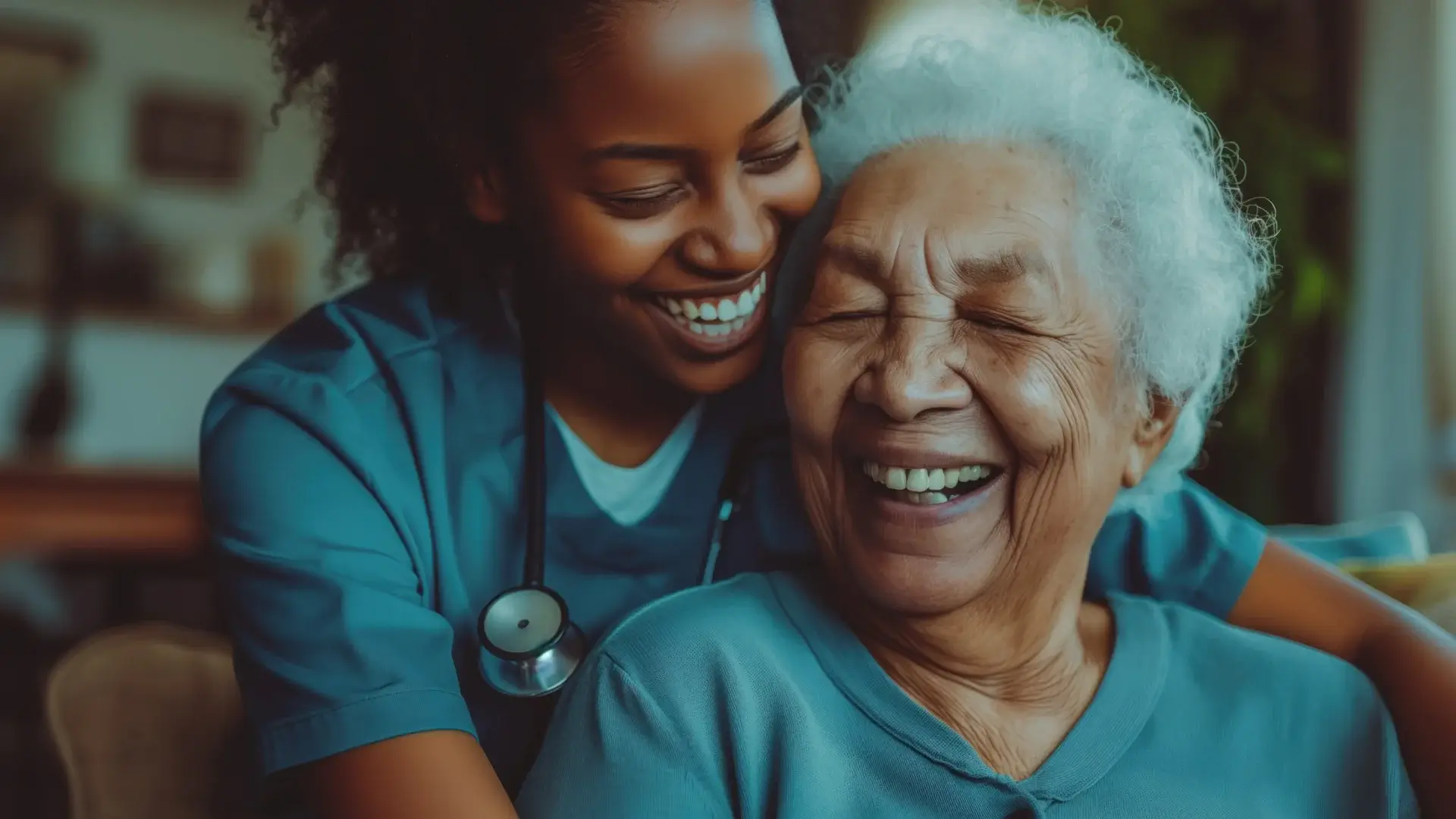 Nurse hugging and laughing with an elderly patient