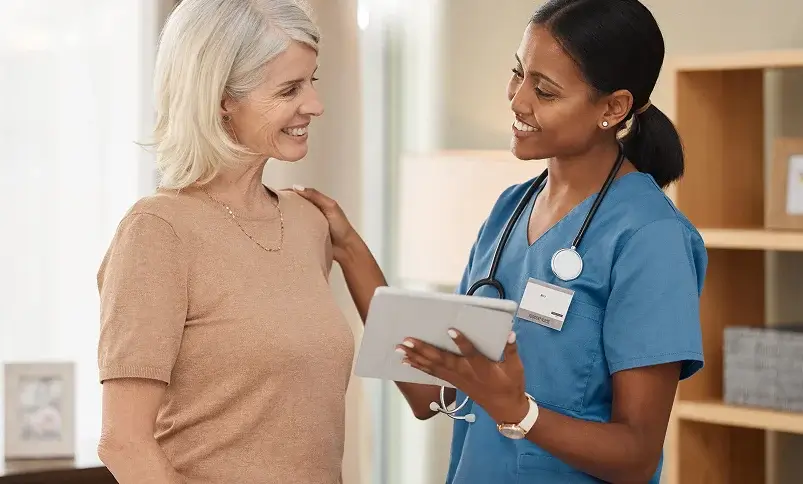 Healthcare professional consulting with a senior woman patient using a digital tablet